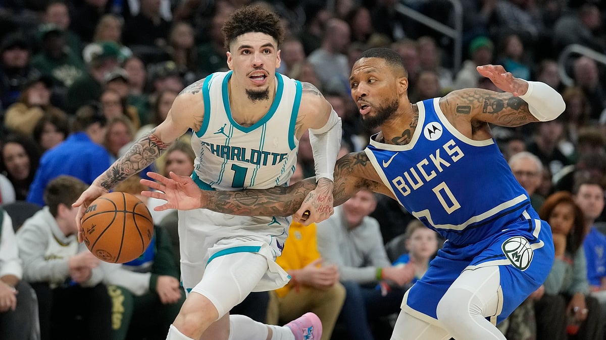 LaMelo Ball #1 of the Charlotte Hornets dribbles the ball against Damian Lillard #0 of the Milwaukee Bucks during the fourth quarter of a game at Fiserv Forum on November 23, 2024 in Milwaukee, Wisconsin.