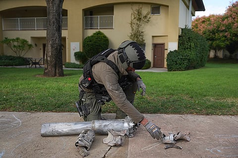Tensions in the Middle East: An Israeli bomb squad officer gathers the fragments of a rocket fired from Lebanon