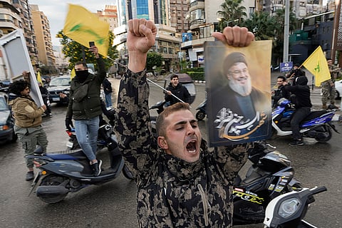 Israel Lebanon: A man celebrating the ceasefire carries the photo of Hassan Nasrallah.
