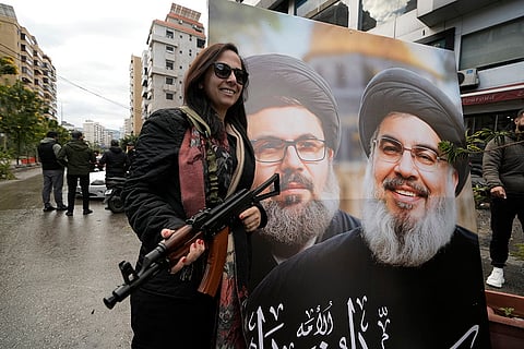 Israel Lebanon Ceasefire: A woman poses in front of a picture of Hassan Nasrallah