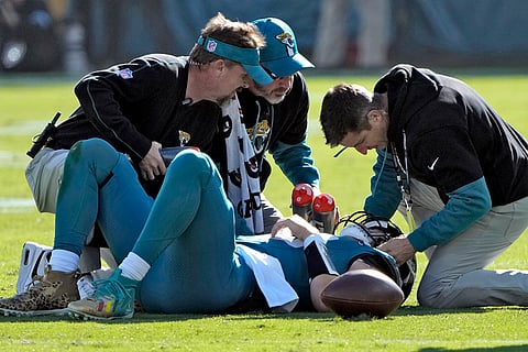 Texans vs Jaguars NFL Football: Jaguars quarterback Trevor Lawrence (16) is looked at by trainers after a late hit by Azeez Al-Shaair