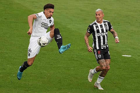 Copa Libertadores Final: Adryelson of Botafogo, left, controls the ball as challenged by Eduardo Vargas of Atletico Mineiro