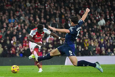 EPL 2024-25: Arsenal's Bukayo Saka, left, kicks the ball as Manchester United's Harry Maguire tries to stop him