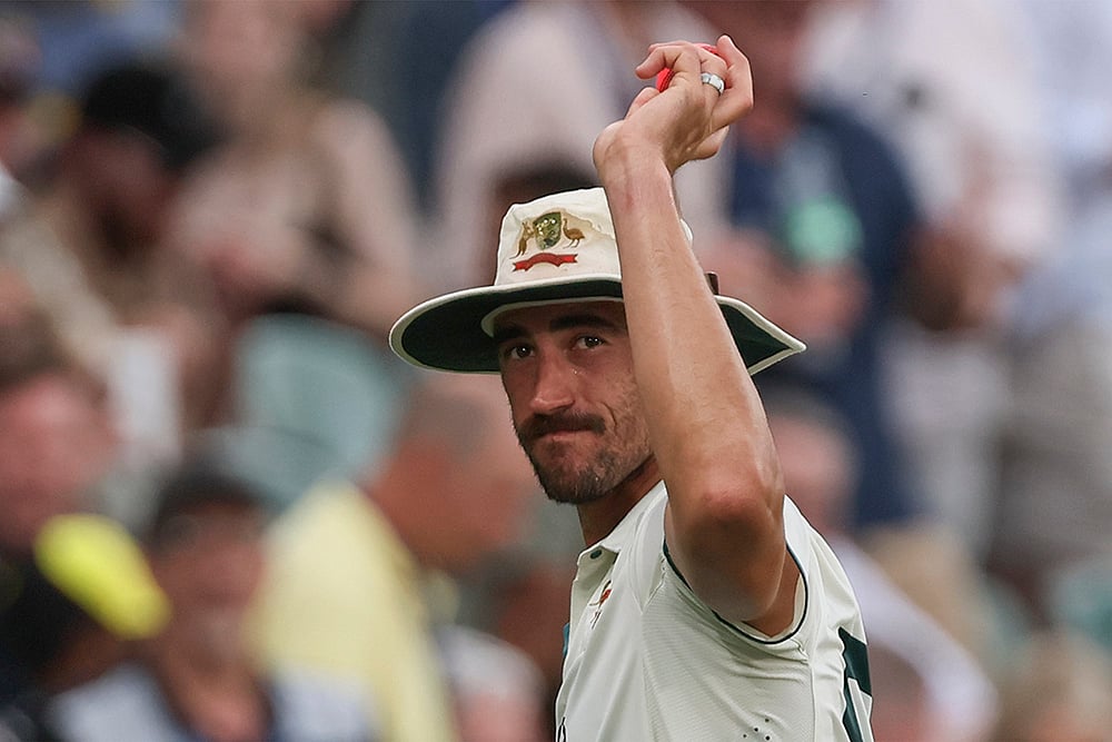 | Photo: AP/James Elsby : IND Vs AUS 2nd Test Day 1: Australia's Mitchell Starc holds up the ball to celebrate a six-wicket haul
