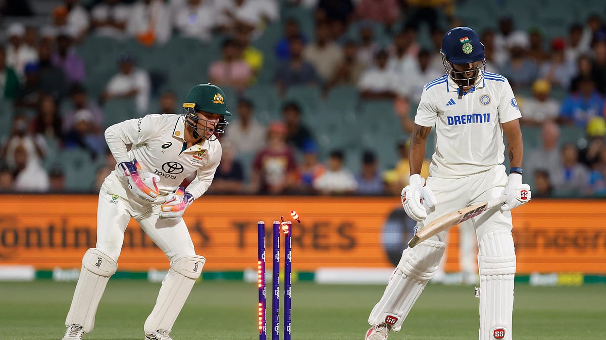 Australias wicketkeeper Alex Carey, left, breaks the stumps. AP Photo