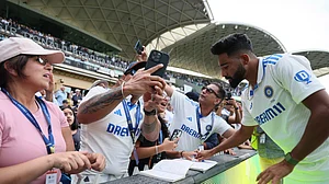 AP Photo/James Elsby : India's Mohammed Siraj signs autographs for fans after the second cricket test match between Australia and India at the Adelaide Oval.