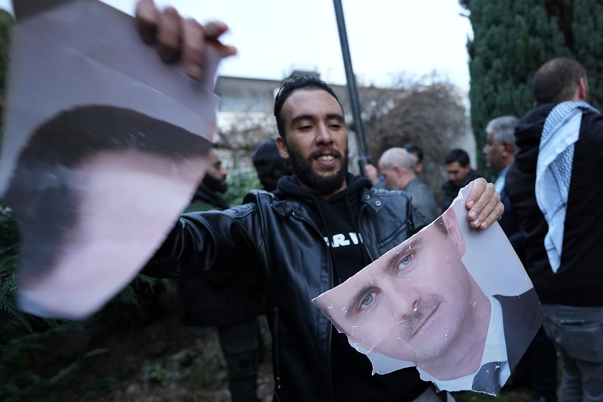 AP Photo/Darko Vojinovic : A man tears photo of Syrian President Bashar Assad in front of the Syrian embassy in Belgrade, Serbia, Sunday, Dec. 8, 2024. 