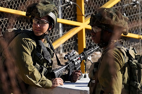 Israeli soldiers stand guard at near the Alpha Line in Golan Heights