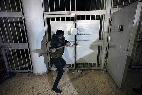 A man breaks the lock of a cell in the infamous Saydnaya military prison, just north of Damascus, Syria.