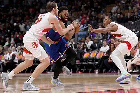 NBA Basketball: Knicks center Karl-Anthony Towns, center, drives between Raptors center Jakob Poeltl and Scottie Barnes