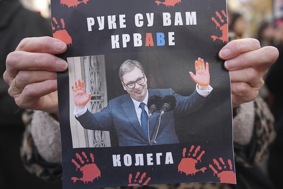 AP : Woman holds a banner that shows Serbian President Aleksandar Vučić, reading: 'You have blood on your hands'