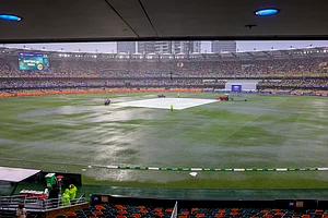 AP Photo/Pat Hoelscher : General view of covers on the pitch as it rain during play on day one of the third cricket test between India and Australia at the Gabba in Brisbane, Australia, Saturday, Dec. 14, 2024.