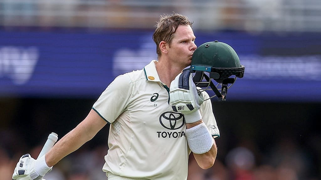Australia's Steve Smith kisses his helmet after scoring century during play on day two of the third cricket test between India and Australia at the Gabba in Brisbane, Australia, Sunday, Dec.15, 2024 - (AP Photo/Pat Hoelscher)