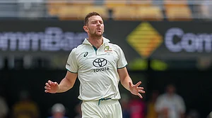 AP Photo/Pat Hoelscher : Australia's Josh Hazlewood reacts after bowling a delivery during play on day three of the third cricket test between India and Australia at the Gabba in Brisbane.