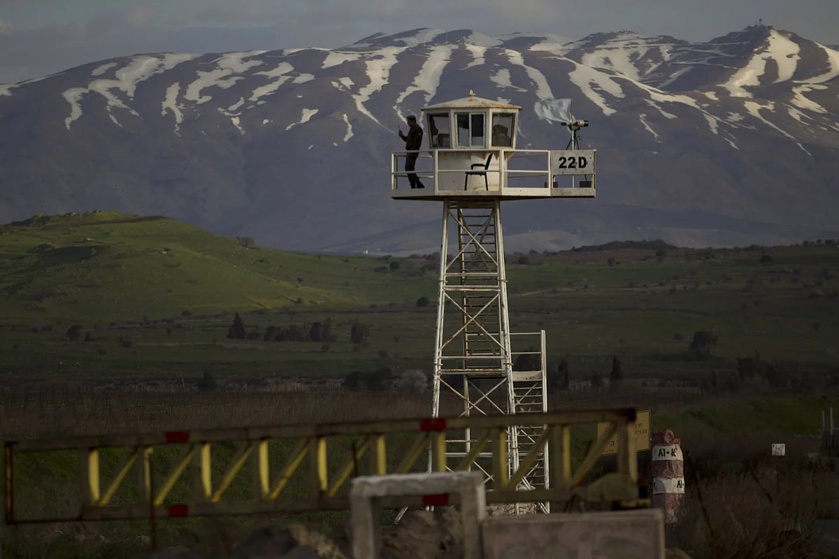 AP : A UN peacekeeper stands guard on a watch tower at a crossing between Syria and Israeli occupied Golan Heights |