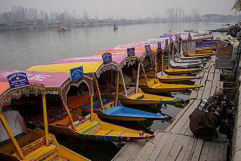 Cold wave in Kashmir valley: Kashmiri boat men sit near a bonfire