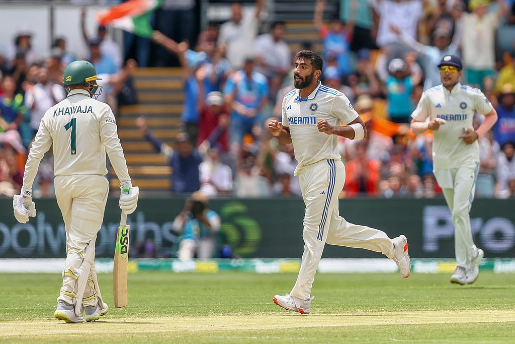 AP Photo/Pat Hoelscher : India's Jasprit Bumrah, center, celebrates the wicket of Australia's Usman Khawaja, left, during play on day five of the third cricket test between India and Australia at the Gabba in Brisbane, Australia, Wednesday, Dec. 18, 2024.