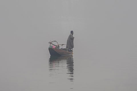 Cold wave in Kashmir valley: A Kashmiri boat man rows his boat on foggy day