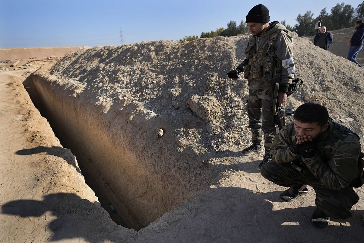 AP : Syrian rebels observe a location identified as a mass grave in Damascus