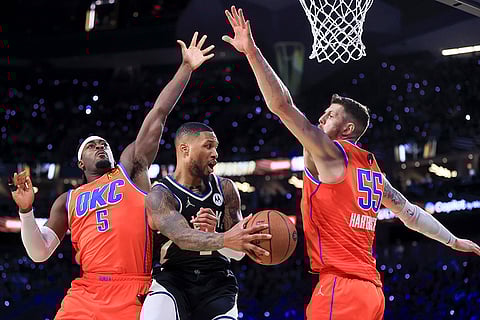NBA Cup Final: Bucks guard Damian Lillard (0) passes between Thunder guard Luguentz Dort (5) and center Isaiah Hartenstein