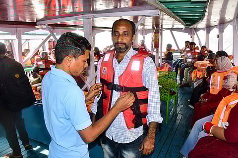 A passenger gets assisted to wear a life jacket