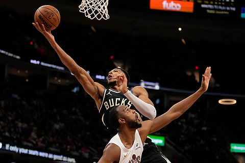 NBA 2024-25: Bucks forward Giannis Antetokounmpo, left, shoots over Cavaliers forward Evan Mobley