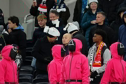 EPL 2024-25: People dressed as Squid Games guards or pink soldiers stand in the spectators area