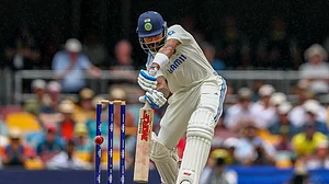 AP Photo/Pat Hoelscher : India's Virat Kohli bats during play on day three of the third cricket test between India and Australia at the Gabba in Brisbane, Australia.
