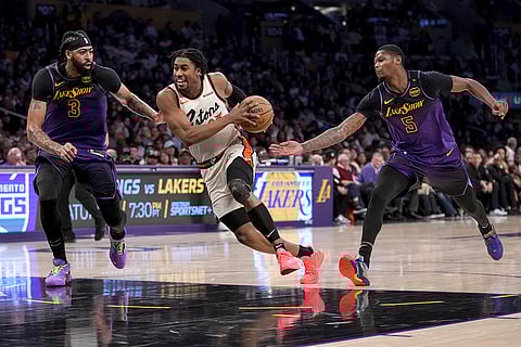 NBA 2024-25: Pistons guard Jaden Ivey dribbles past Lakers forwards Anthony Davis and Cam Reddish