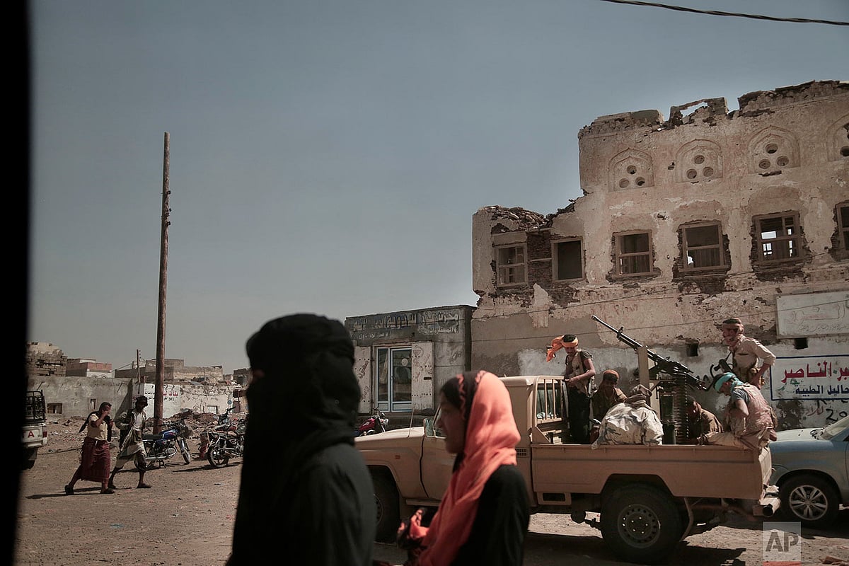 AP/Nariman El-Mofty : Women walk past Saudi-led coalition backed forces, leading the campaign to take over Hodeida, as they patrol Mocha, a port city on the Red Sea coast of Yemen |