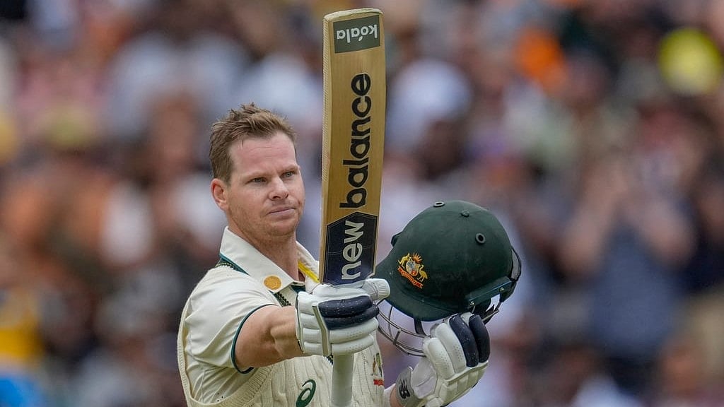 AP Photo/Asanka Brendon Ratnayake : Australia's Steve Smith raises his bat as he celebrates after scoring his century during play on the second day of the fourth cricket test between Australia and India at the Melbourne Cricket Ground, Melbourne, Australia, Friday, Dec. 27, 2024. 