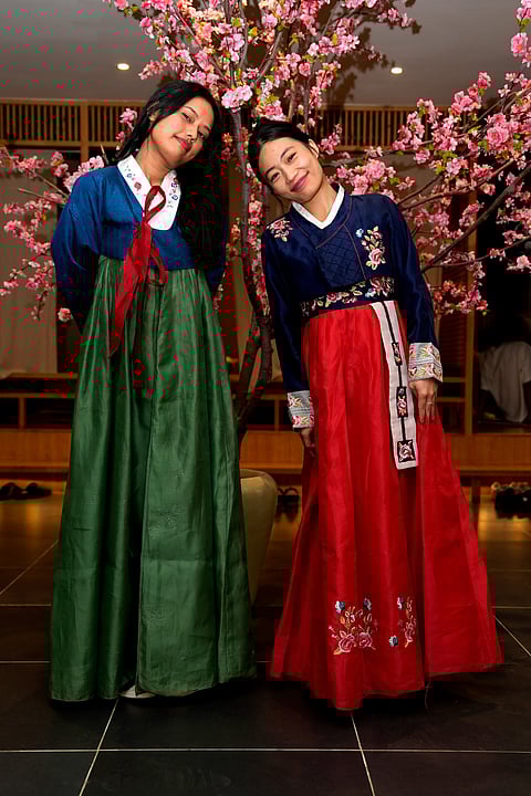 Two young girls pose in vibrant and elegant traditional Korean ‘Hanbok’ dresses. 