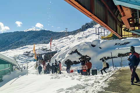 Tourists amid snowfall in Chamoli