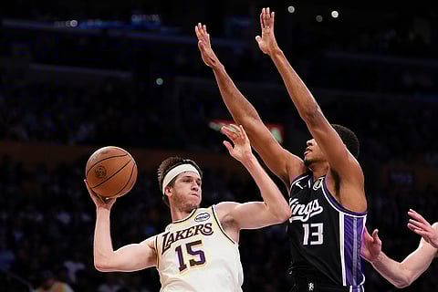 NBA: Lakers guard Austin Reaves passes while under pressure from Kings forward Keegan Murray