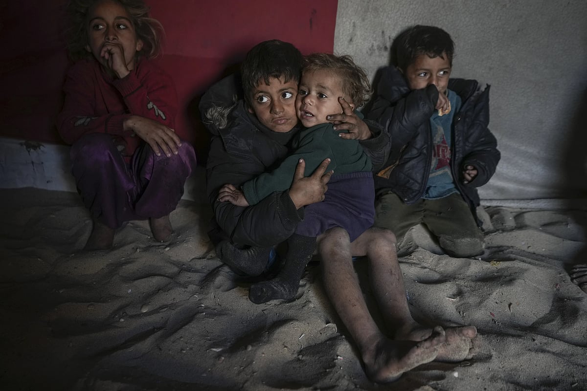 PTI : Palestinian Tamim Marouf, 6, sits inside his family's tent alongside his sister Hala, 10, and his brother Malek, 4, at a camp for internally displaced Palestinians on the beachfront in Deir al-Balah, central Gaza Strip, Friday, Dec. 27, 2024.