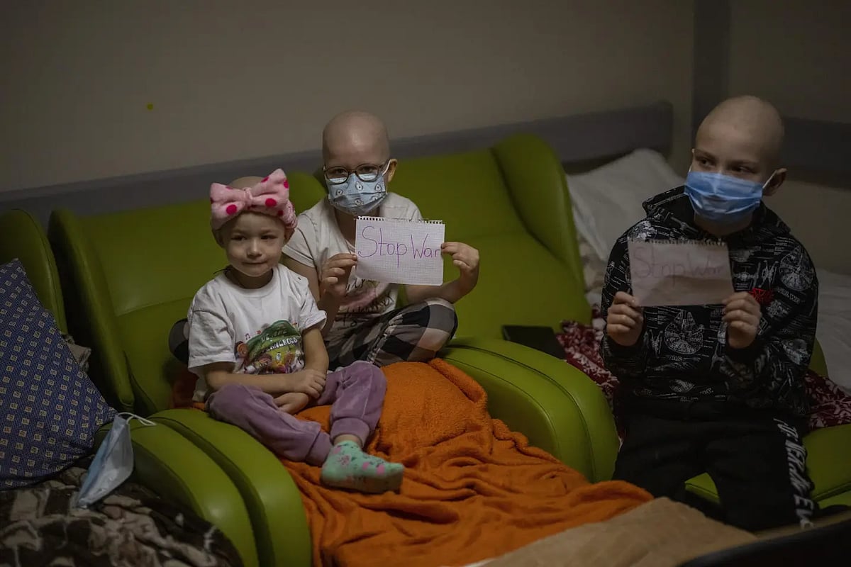 AP /Emilio Morenatti : Oncology patients hold up sheets of paper with the words "Stop War" in a basement used as a bomb shelter at the Okhmadet children's hospital in central Kyiv, Ukraine, Monday, Feb. 28, 2022 |