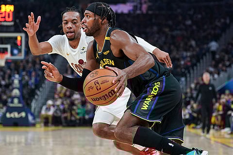 NBA 2024-25: Warriors guard Buddy Hield moves the ball while defended by Cavaliers guard Darius Garland