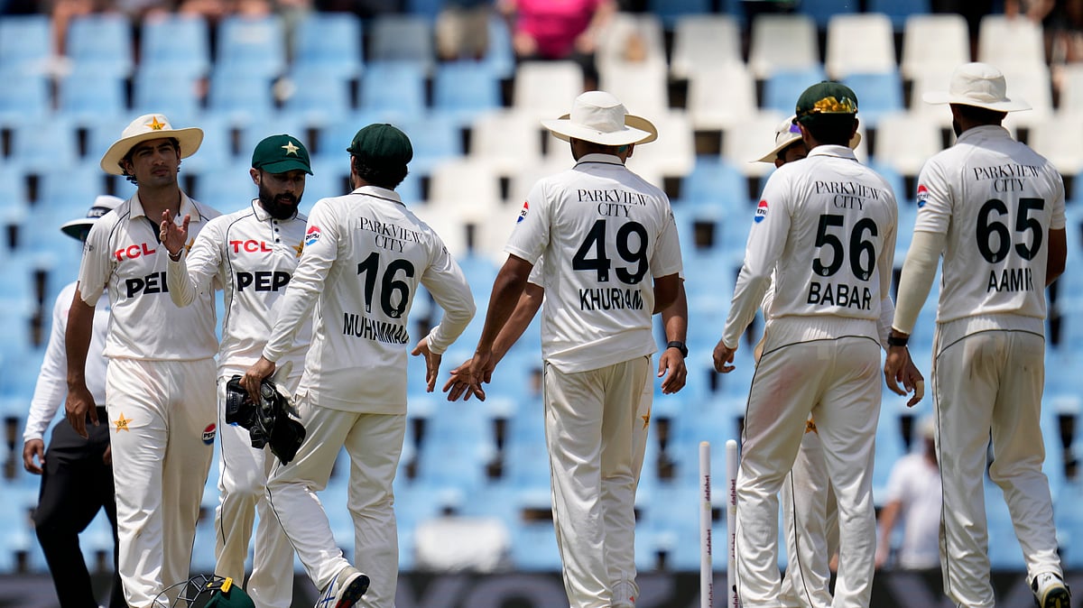 AP Photo/Themba Hadebe : Pakistan's Babar Azam, second from left, shakes hand with teammate Mohammad Rizwan following the day four of the Test cricket match between South Africa and Pakistan, at the Centurion Park in Centurion.
