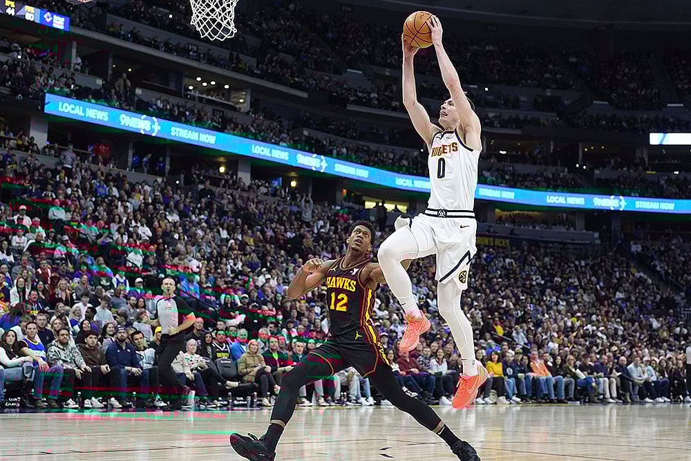 | Photo: AP/David Zalubowski : NBA 2024-25: Nuggets guard Christian Braun, front, drives to the basket