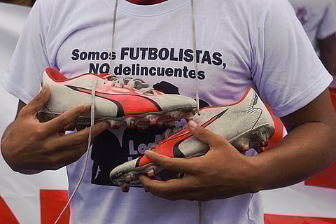 Ecuador Missing Children: A protester holds soccer cleats