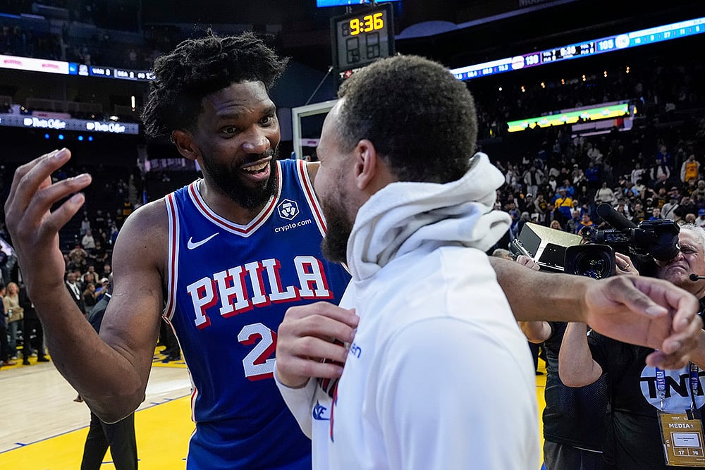 | Photo: AP/Godofredo A. Vásquez : NBA 2024-25: 76ers center Joel Embiid, left, speaks with Warriors guard Stephen Curry 