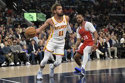NBA 2024-25: Hawks guard Trae Young, left, is defended by Clippers guard Norman Powell