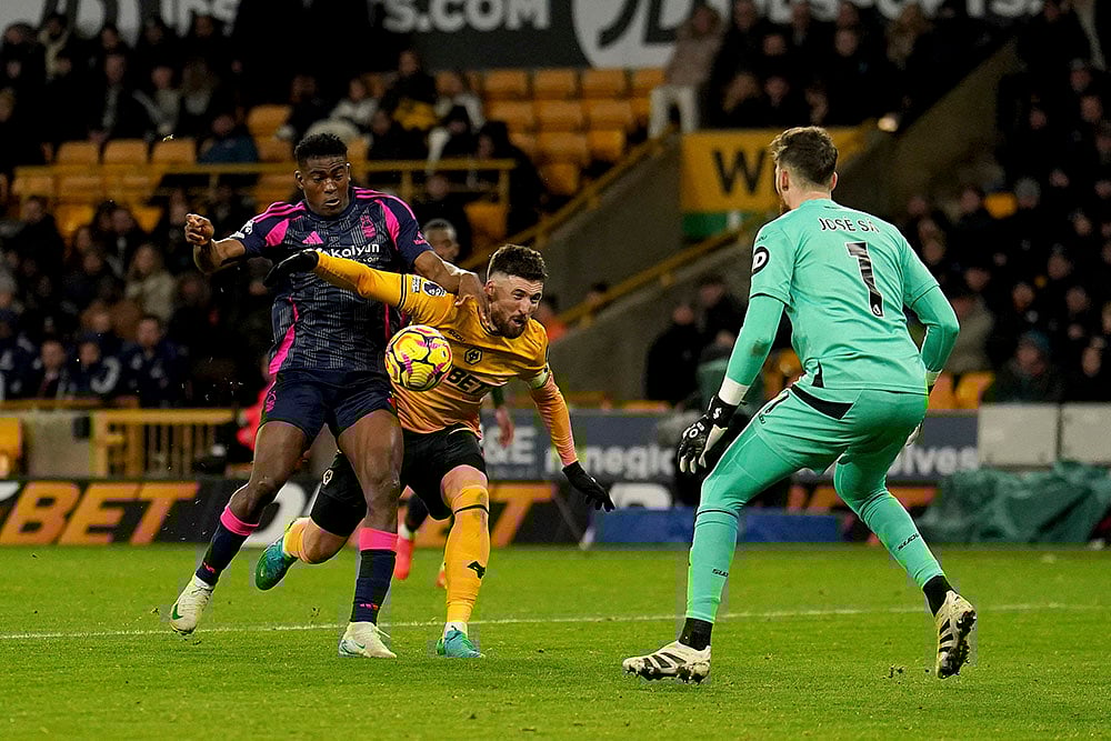 | Photo: Martin Rickett/PA via AP : EPL 2024-25: Nottingham Forest's Taiwo Awoniyi and Wolves Matt Doherty, centre, battle for the ball