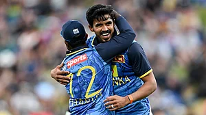 Andrew Cornaga/Photosport via AP : Sri Lanka bowler Maheesh Theekshana, right, celebrates his hat-trick with his captain Charith Asalanka during their one-day international cricket match against New Zealand in Hamilton.