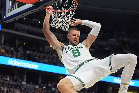 NBA 2024-25: Celtics center Kristaps Porzingis hangs from the rim after dunking