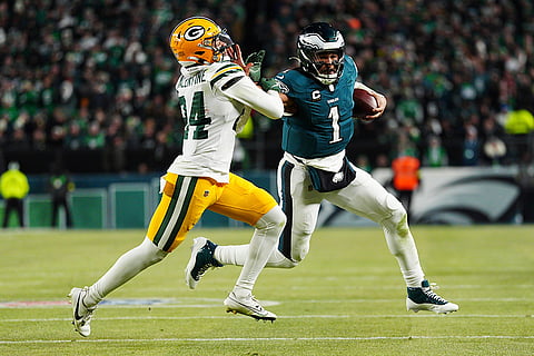 NFL Football Play-off - Packers vs Eagles: Eagles quarterback Jalen Hurts (1) stiff arms Packers cornerback Carrington Valentine
