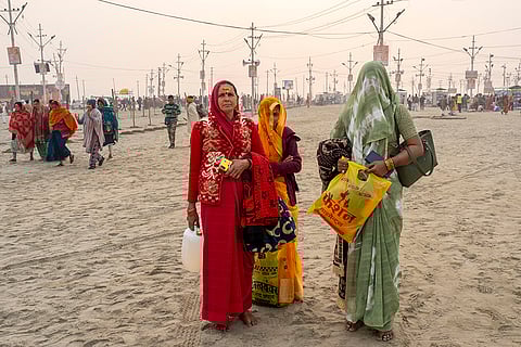 Kumbh Mela 2025: Women wait to join their family members after bathing at the confluence