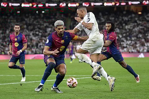 Spanish Super Cup 2025 Final: Real Madrid's Kylian Mbappe challenges for the ball with Barcelona's Ronald Araujo