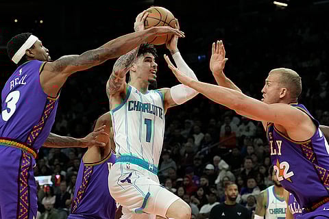NBA 2024-25: Hornets guard LaMelo Ball (1) drives between Suns guard Bradley Beal (3) and center Mason Plumlee