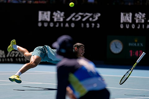 Australian Open 2025: Carlos Alcaraz falls as he reaches for a backhand return to Nuno Borges